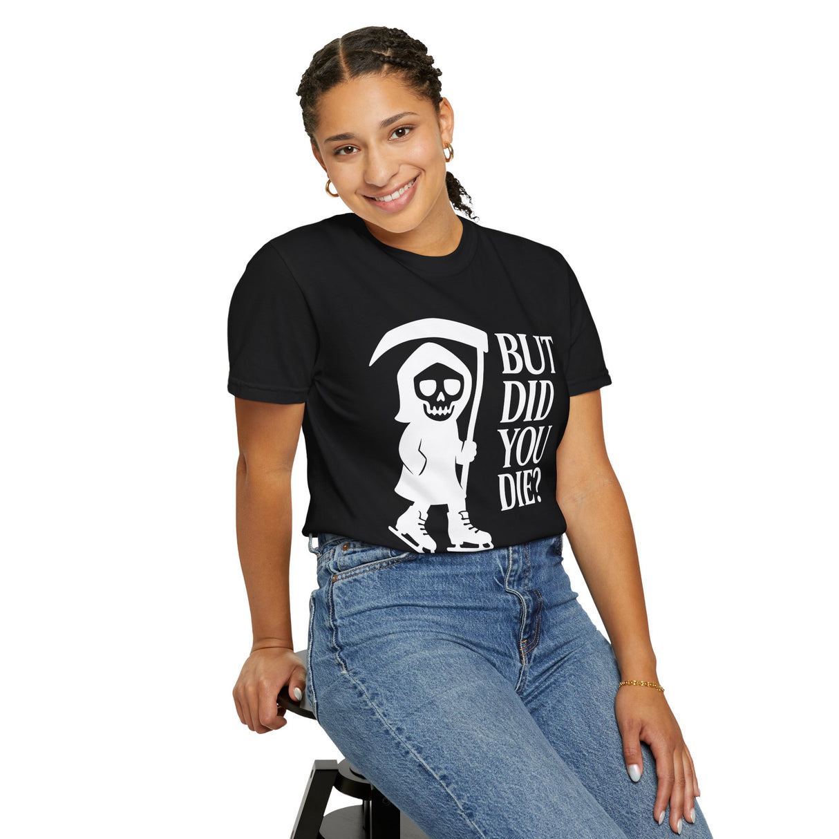 Person wearing a black t-shirt with a graphic design and text, sitting on a stool against a white background.