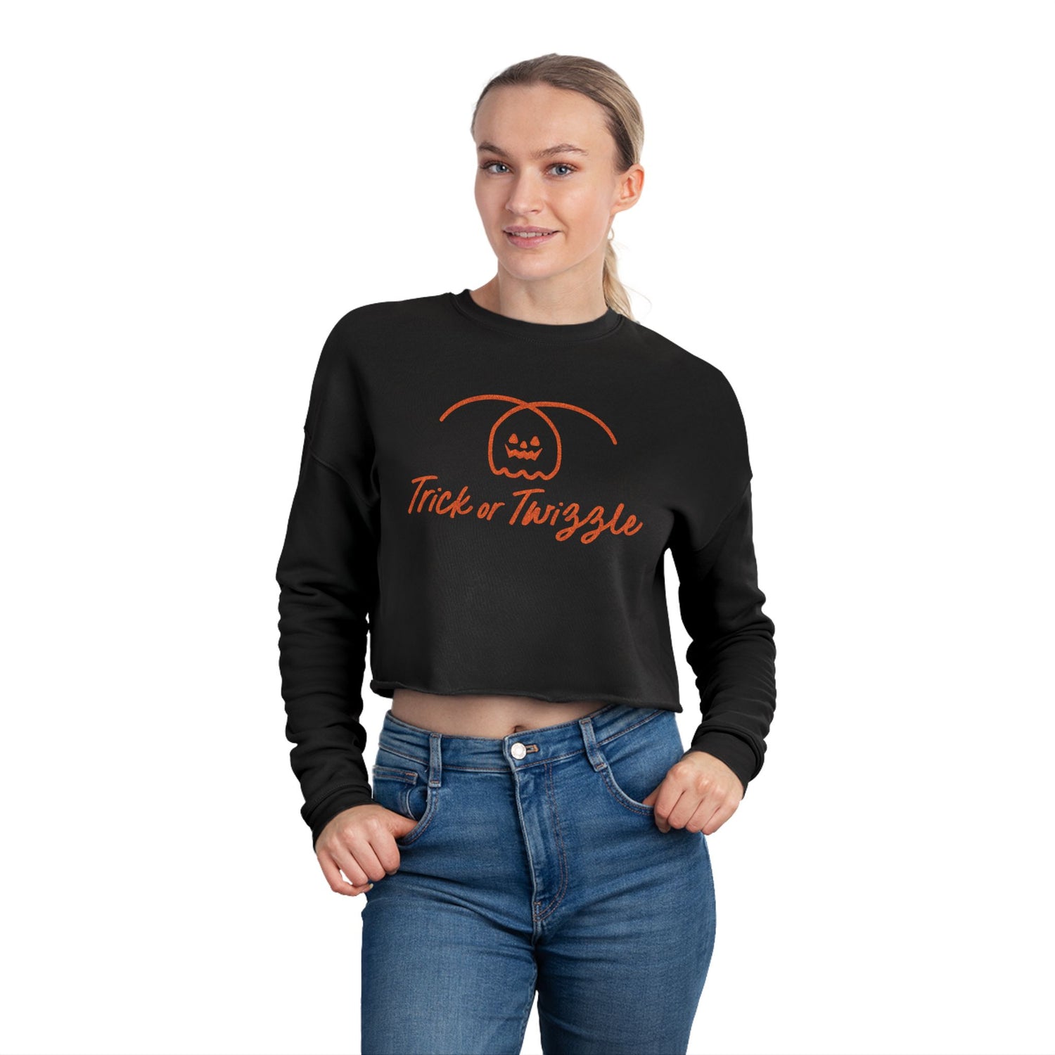 Person wearing a black crop top with 'Trick or Twizzle' text and pumpkin design on a white background