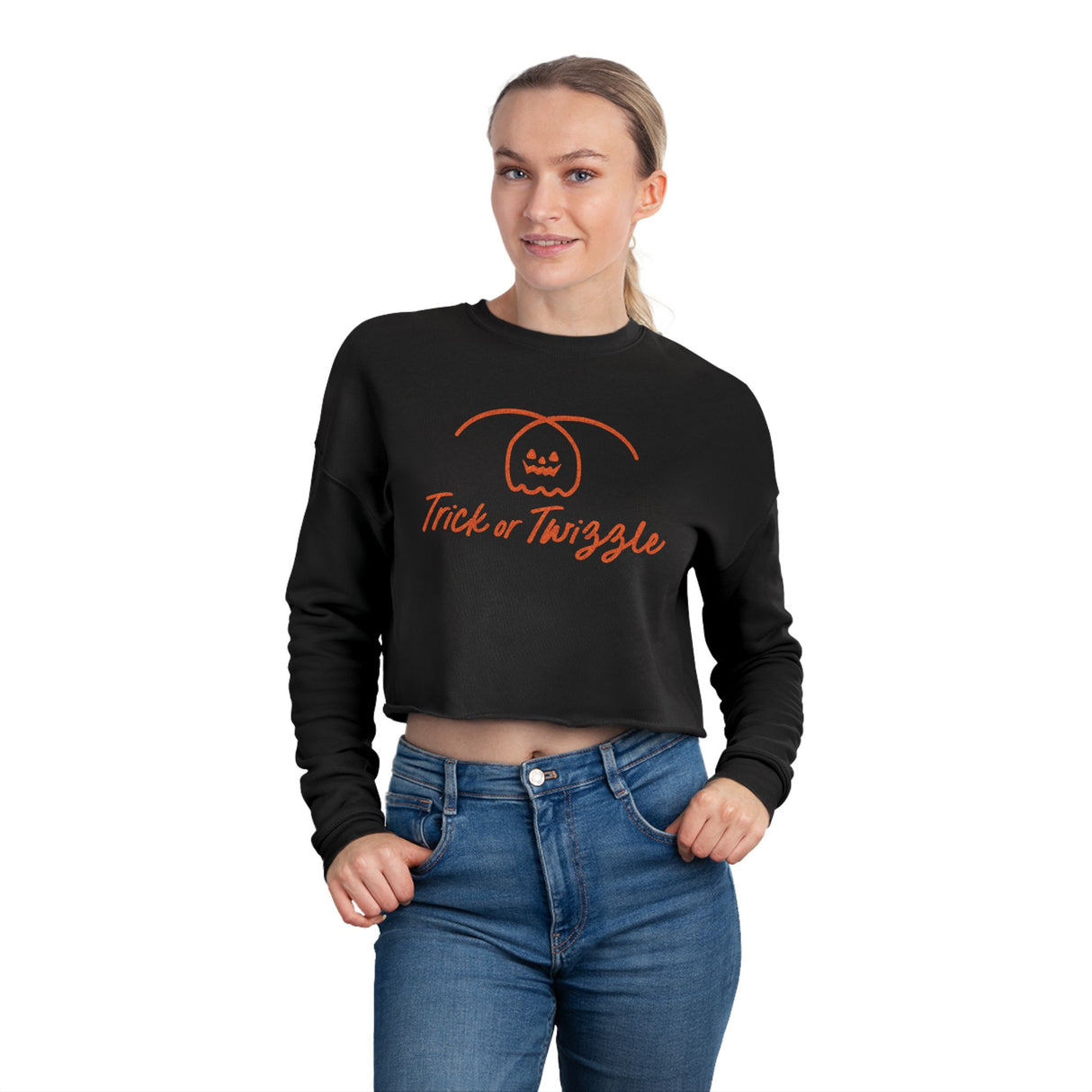 Person wearing a black crop top with 'Trick or Twizzle' text and pumpkin design on a white background