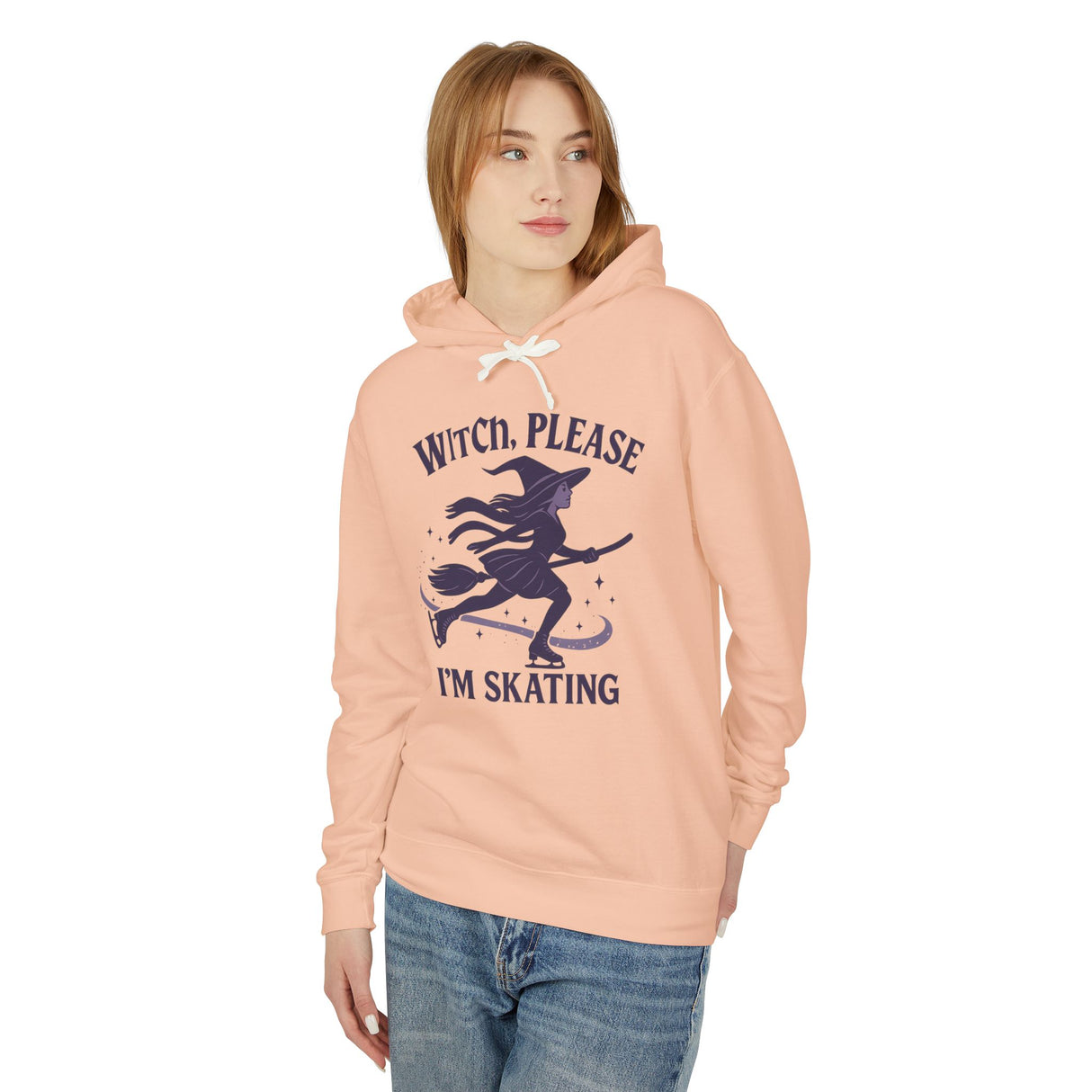 Woman wearing a peach hoodie with a witch graphic and text on a white background