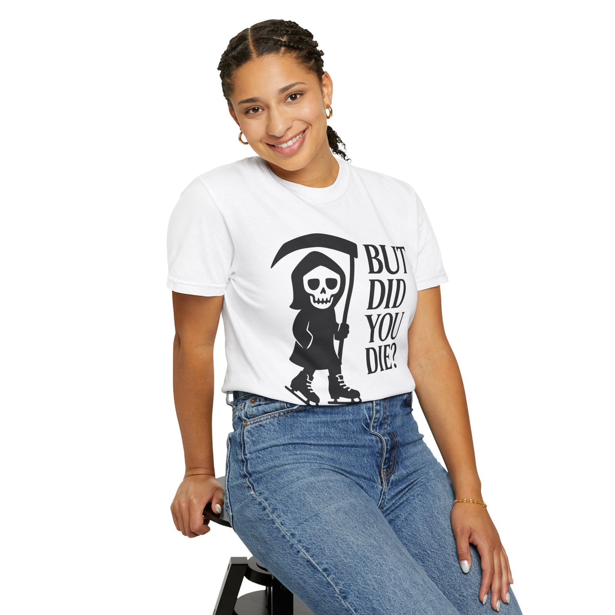 Person wearing a white t-shirt with a graphic design and text, sitting on a stool against a white background.