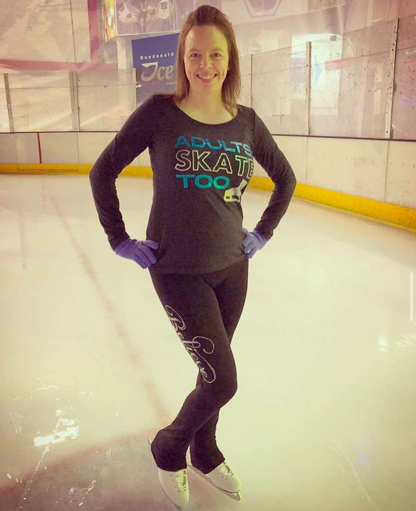Smiling skater in a grey Adults Skate Too long-sleeve top and purple gloves on the ice