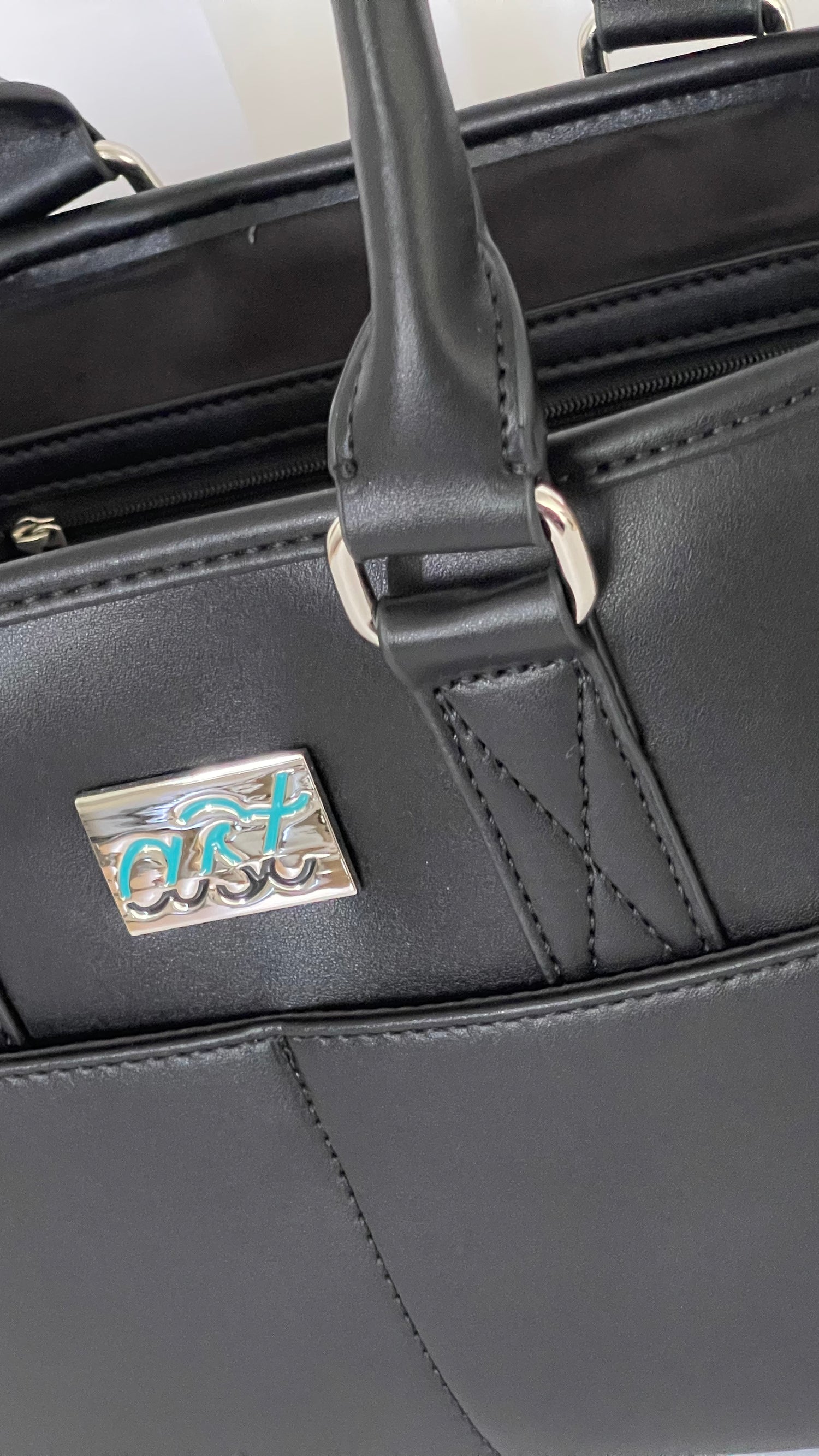 Black handbag with a visible brand logo on a white background