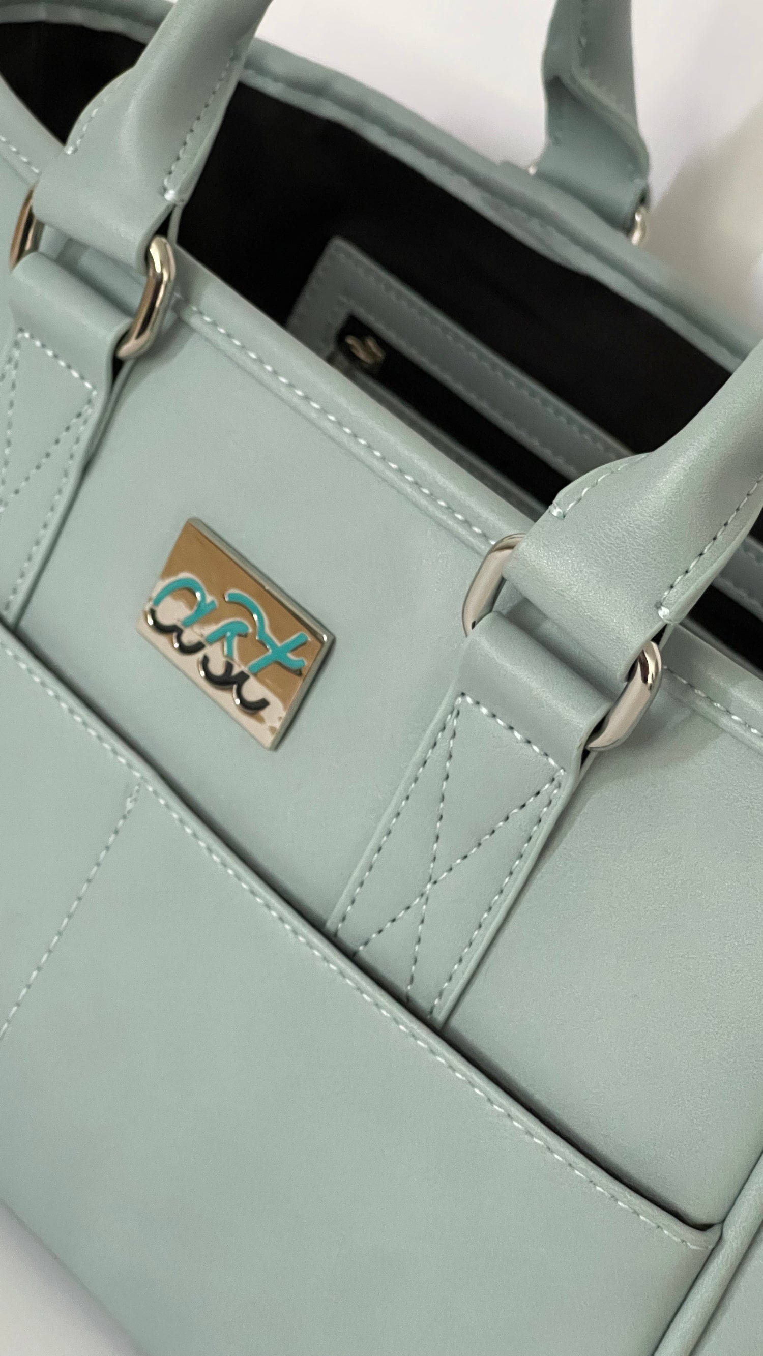Light blue handbag with a visible brand logo on a white background