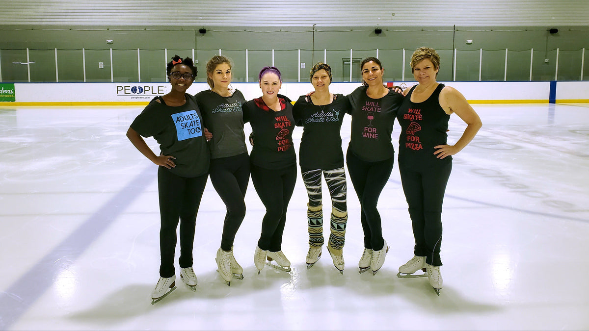 Six adult skaters in a row on the ice at the rink