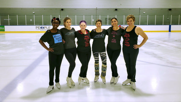 Six adult skaters in a row on the ice at the rink