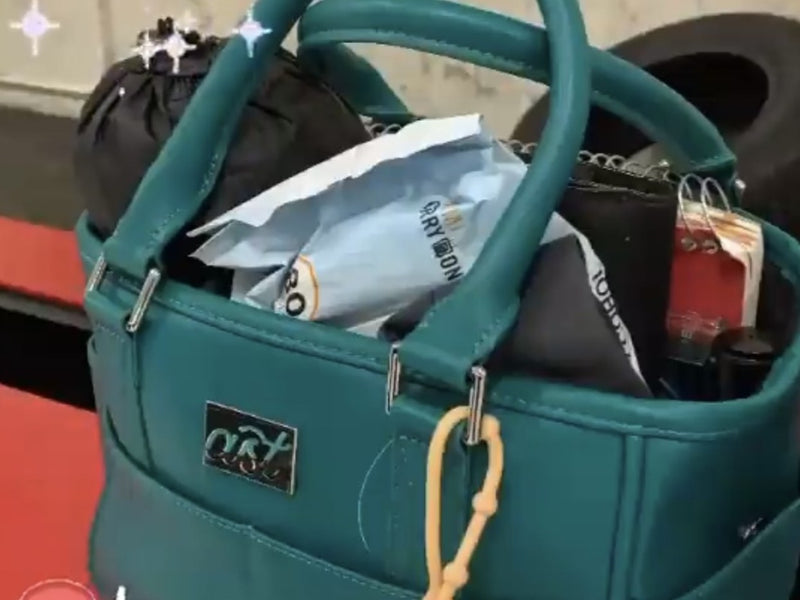 A teal Rink Side Tote packed for a session, with a donut charm on the handle