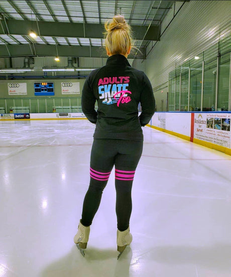 A skater seen from behind in an Adults Skate Too jacket, looking out across the ice.