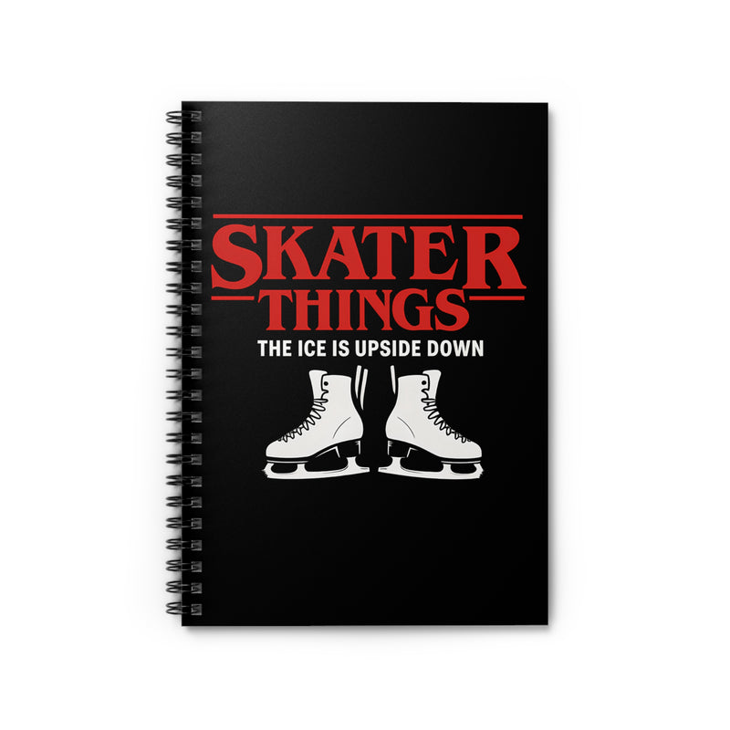 Black notebook with red and white text and ice skates on a white background