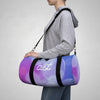 Person carrying a purple and blue duffel bag with 'ast' logo on a gray background