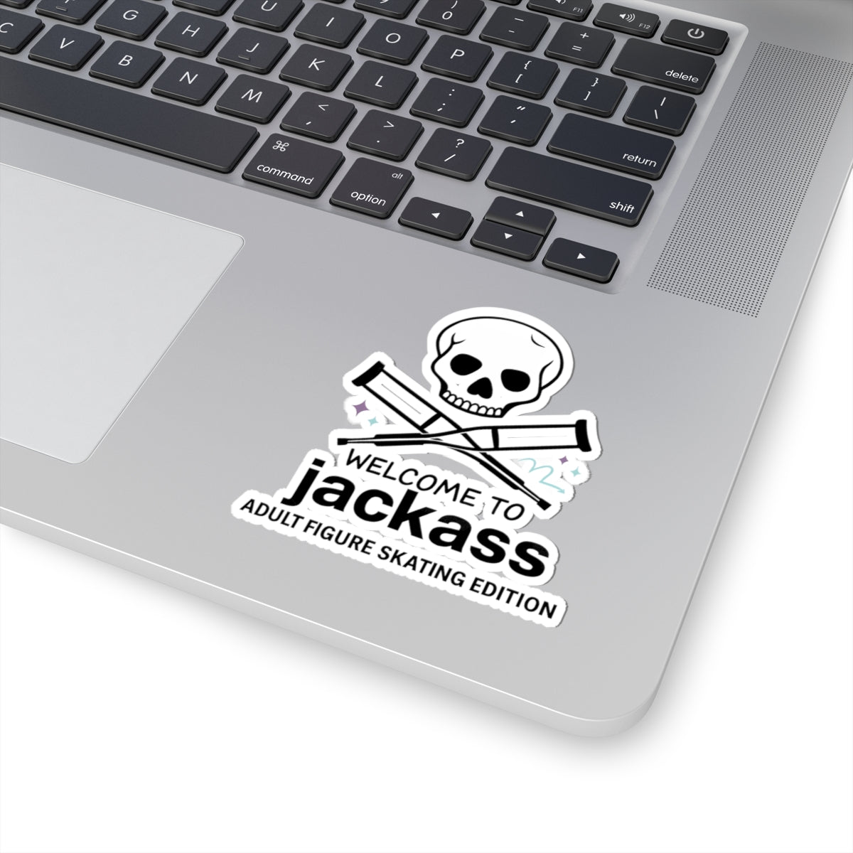 Laptop with a 'Welcome to Jackass' sticker featuring a skull and crossbones design.