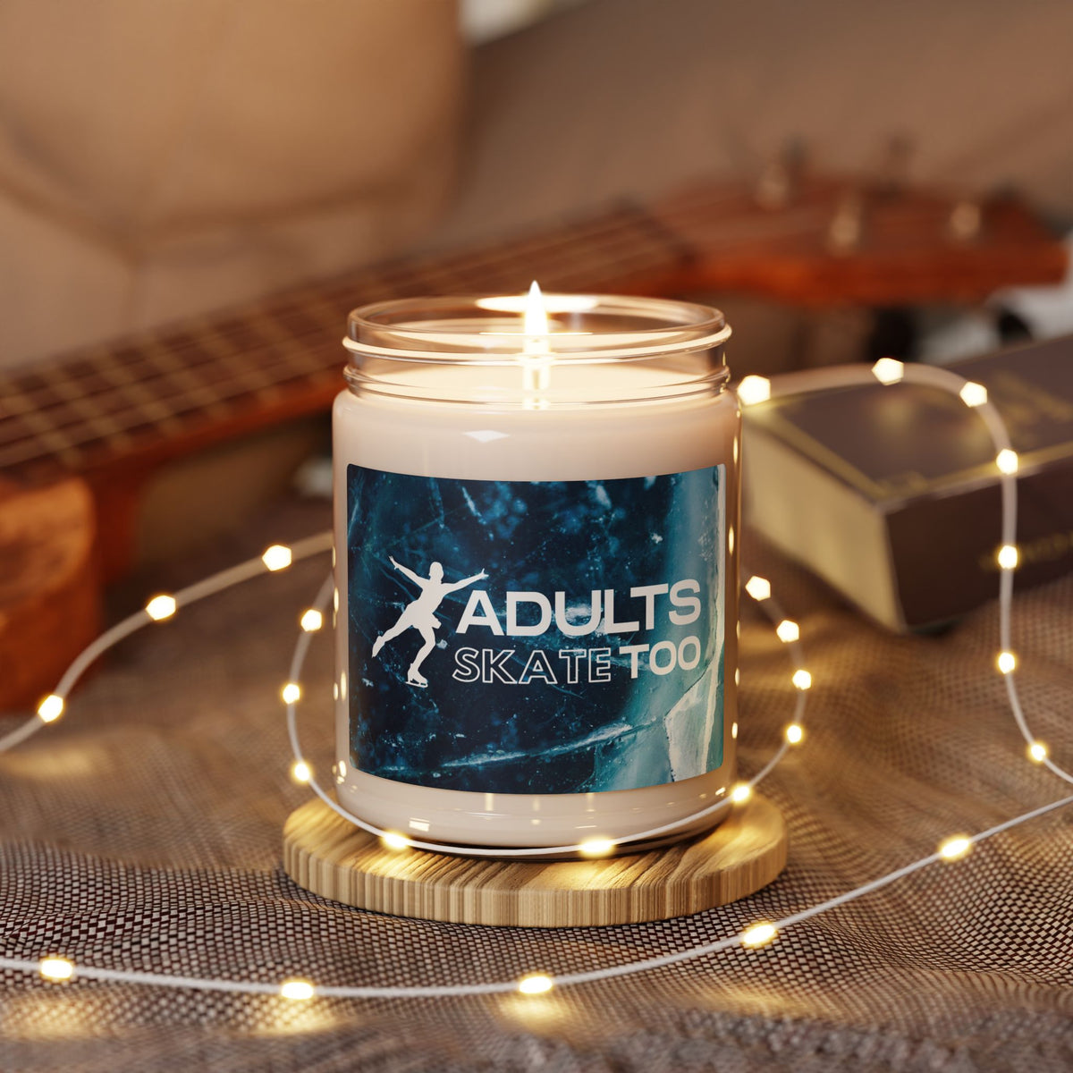 Candle with 'Adults Skate Too' design on a wooden coaster with fairy lights.