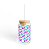 Clear tumbler with colorful pattern, wooden lid, and straw on a white background