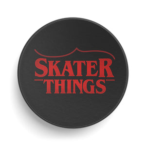 Black circular object with red text 'SKATER THINGS' on a white background