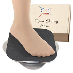 A bare foot on the black grip top of the CRS Cross figure skating spinner, with its box behind