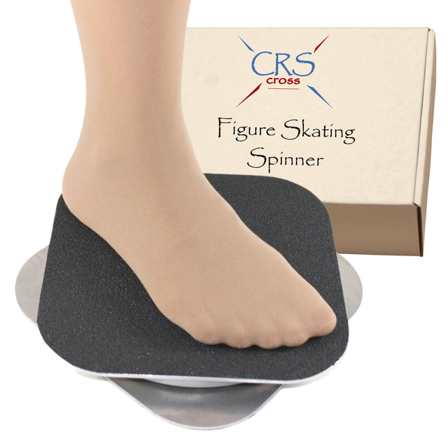 A bare foot on the black grip top of the CRS Cross figure skating spinner, with its box behind