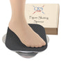 A bare foot on the black grip top of the CRS Cross figure skating spinner, with its box behind