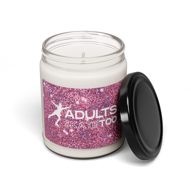 Candle jar with pink glittery label and black lid on a white background