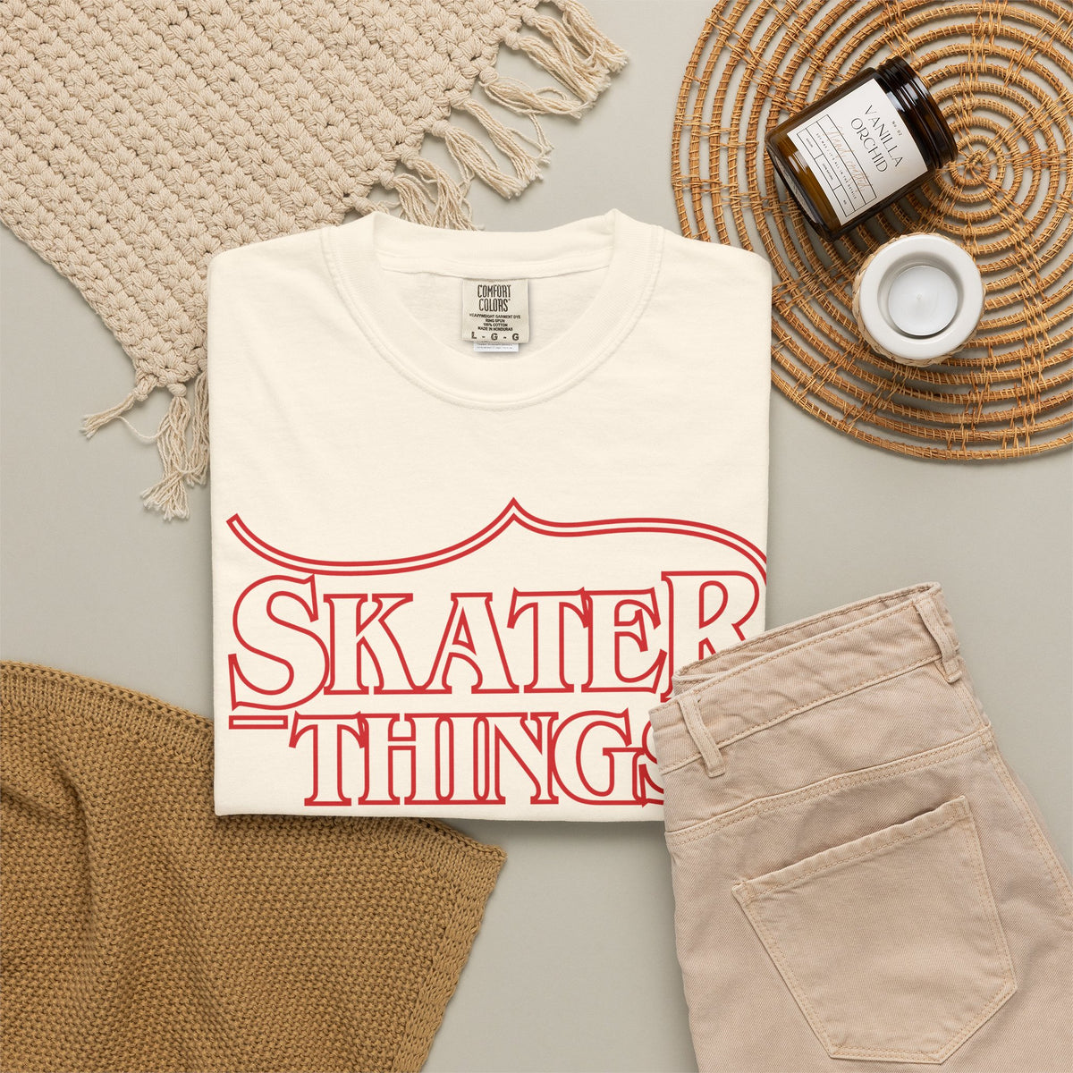 Skater Things T-Shirt in Ivory, folded on a flat lay with jeans