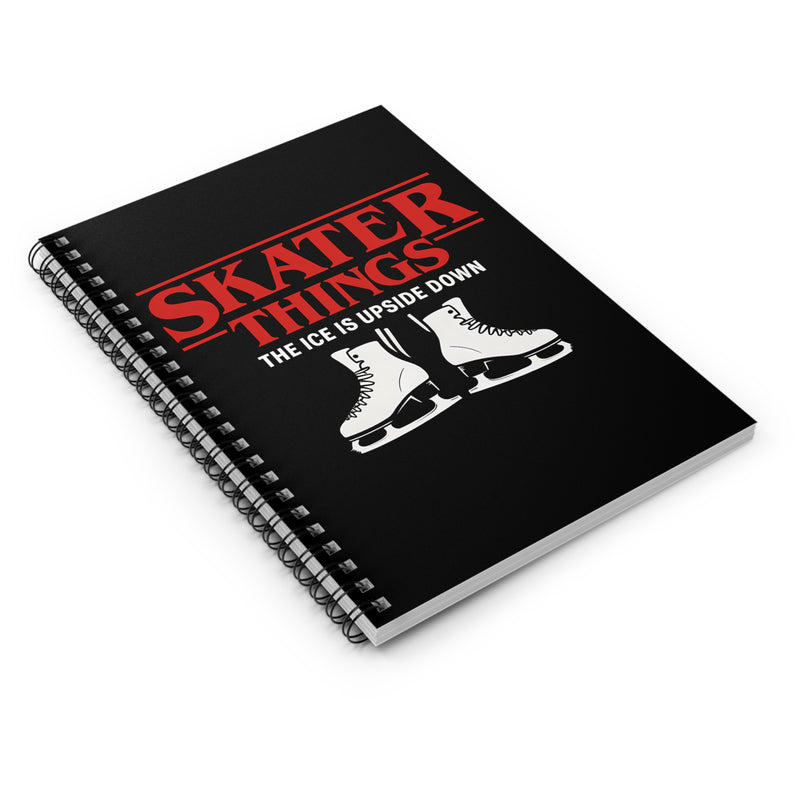 Black notebook with red text and white ice skates on a white background