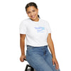 Person wearing a white t-shirt with a logo and text, sitting on a stool against a white background