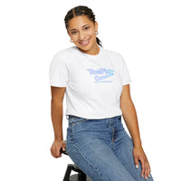 Person wearing a white t-shirt with a logo and text, sitting on a stool against a white background
