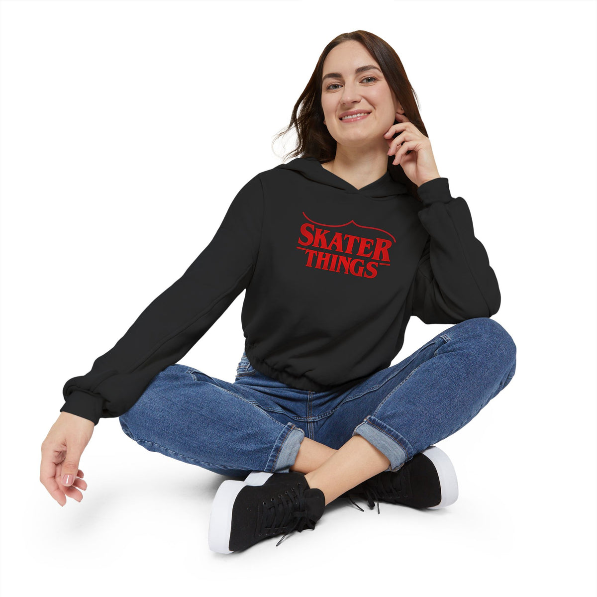 Person wearing a black hoodie with 'Skater Things' text, sitting on a white background