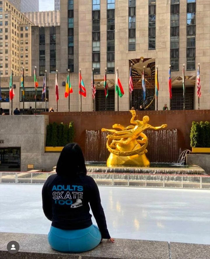 A skater in an Adults Skate Too hoodie at the Rockefeller Center rink