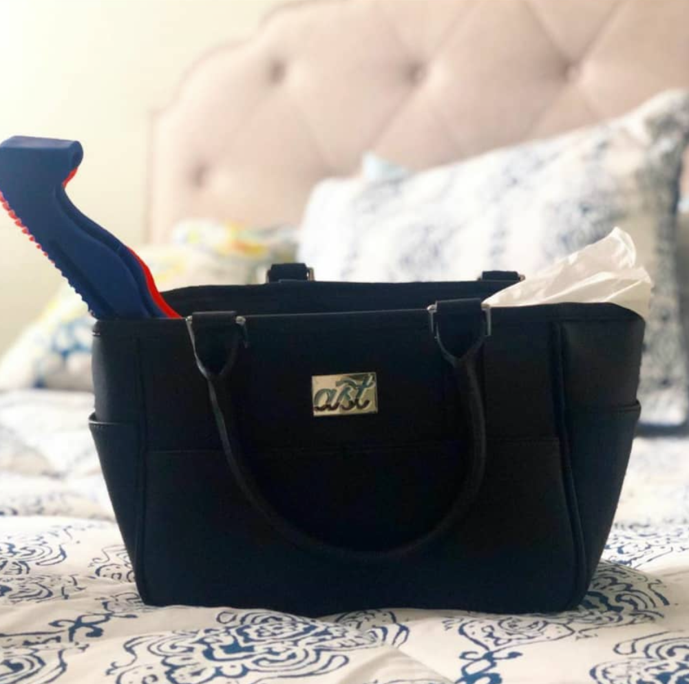 Black bag with gold clasp on a textured surface, with text below.