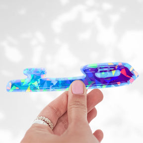 Ombre Blade holographic sticker in the shattered glass finish, a blue to purple skate blade, held in a hand