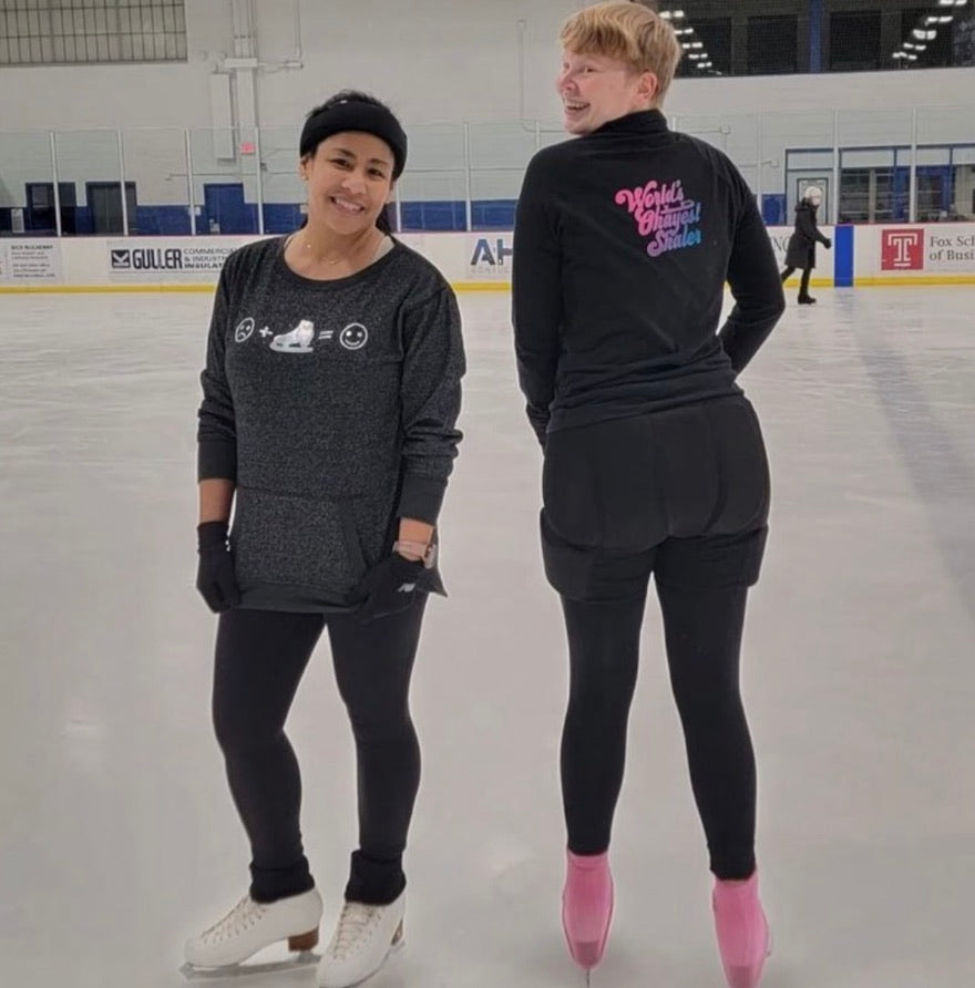 Two skaters on the ice, one in an Emoji top and one in a World's Okayest Skater top