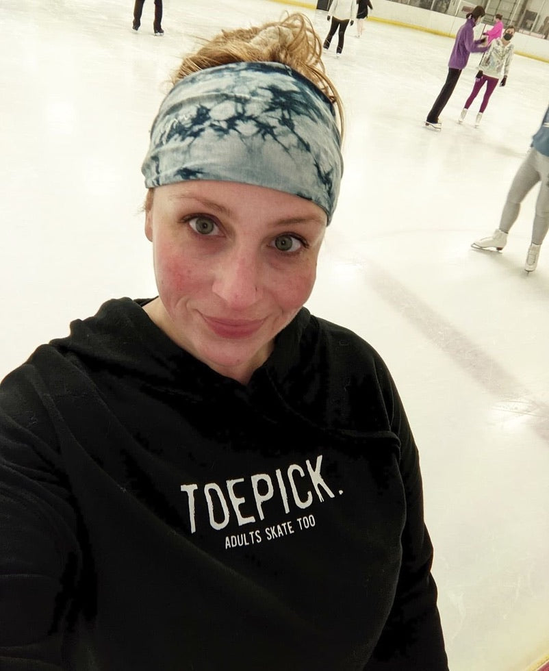 A skater at the rink in a black hoodie with the Toepick design