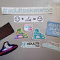 Assorted Adults Skate Too vinyl stickers laid out on a grey table, with the #adultsskatetoo banner across the top