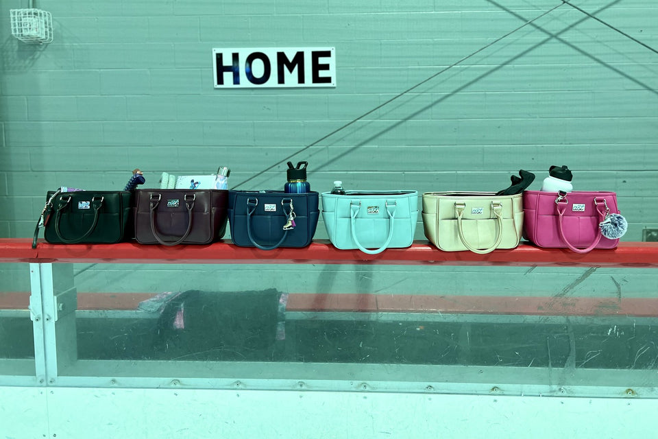Six Rink Side Totes in different colours lined up on the rink boards